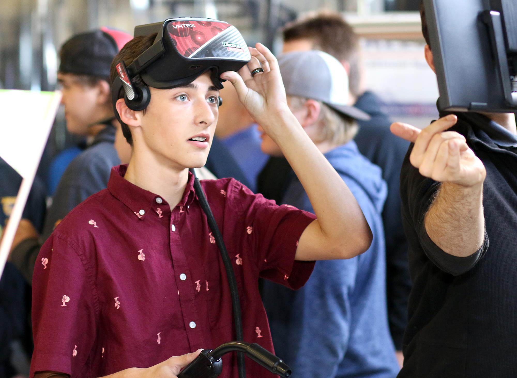 Young man with virtual welding equipment with look of awe