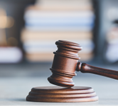 Wooden gavel with papers in the background