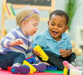 Preschool children playing with legos on the floor