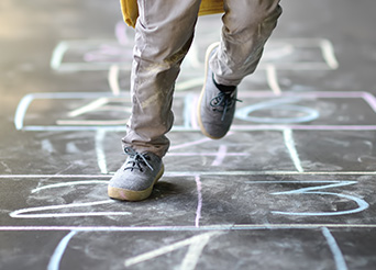 legs of a child playing hopscotch