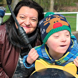 preschool boy who experiences down syndrome swings with his mother