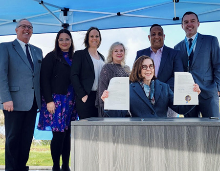 gov kate brown signs senate bill 1545 while washington county leaders look on