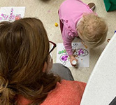 preschooler colors with a dot marker on the floor