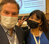 Dan Goldman and Ethelyn Tumalad stand in front of a projector screen