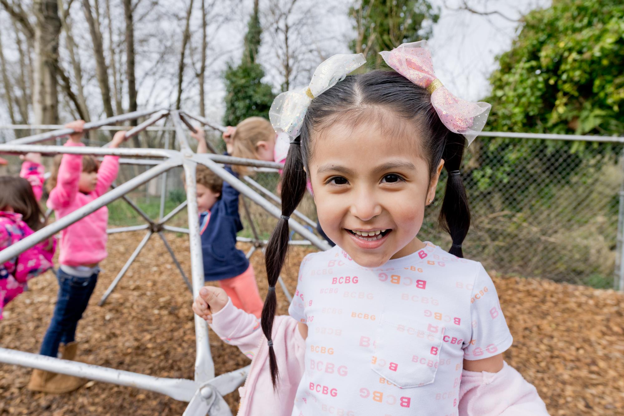 Preschooler stands in front of playground equipment at Tillamook Head Start