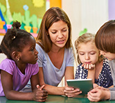 preschool teacher reading with three students