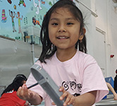 An elementary student plays with water at a museum