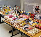 cans and packages of food sit on a long rectangular desk