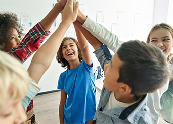 students raise their hands together in a group