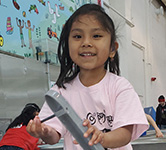 an elementary student explores an exhibit about waves at a museum