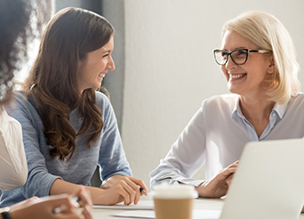 two women look at each other during a meeting