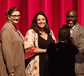 pam voss and holly langan accept an award on stage