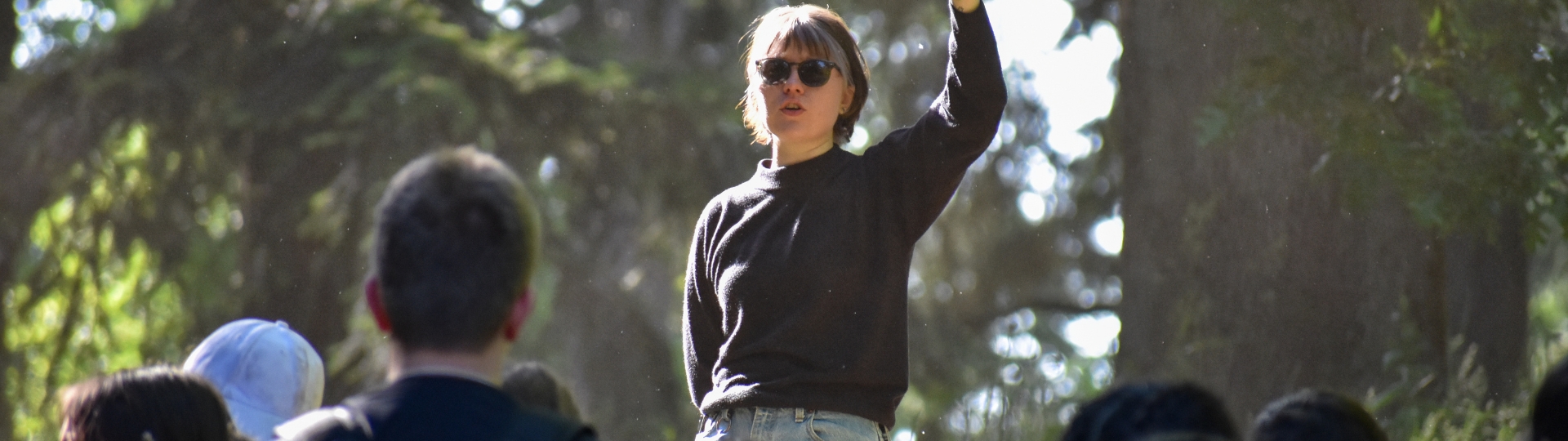 Person with sunglasses talking in front of group of students