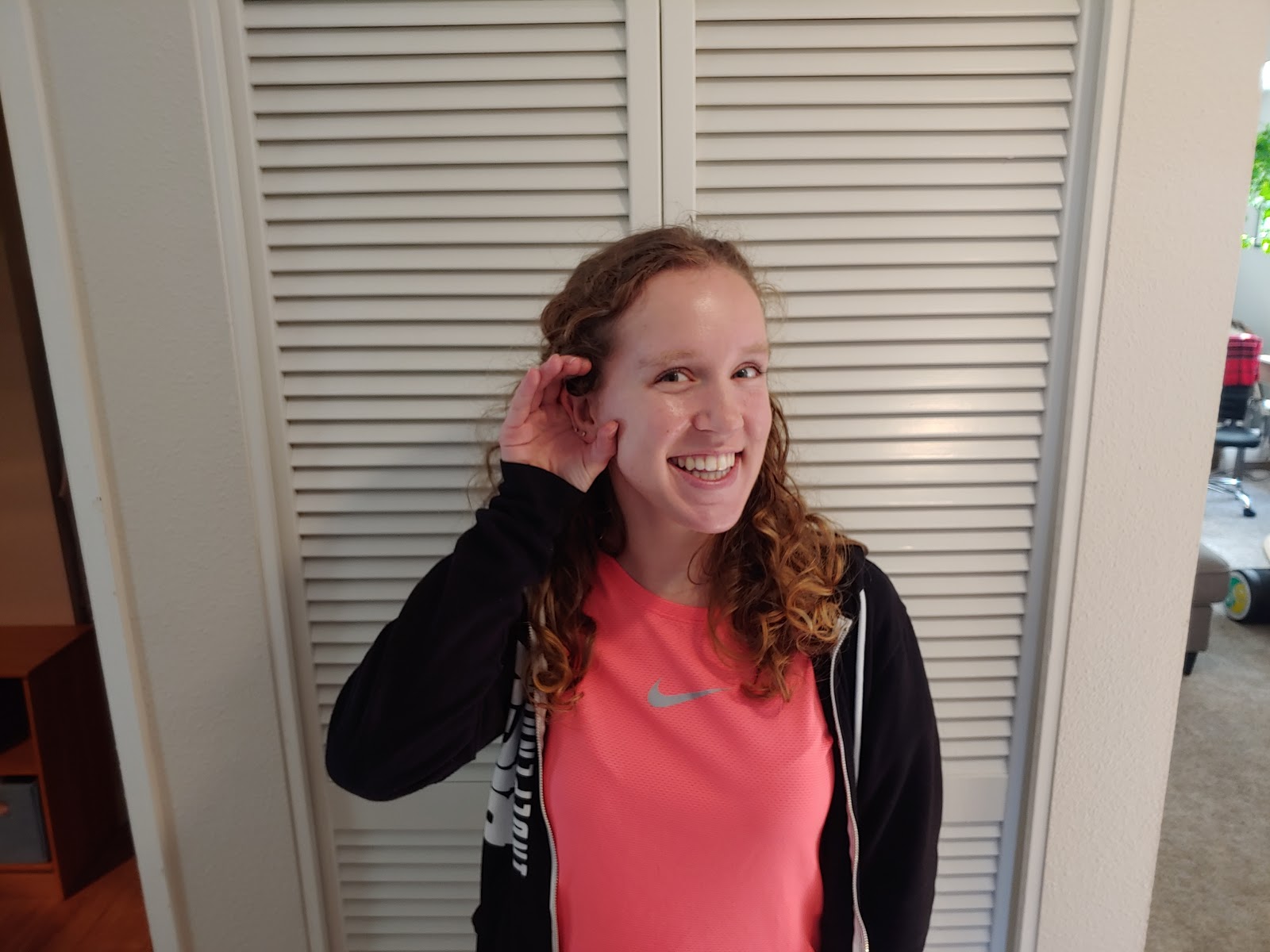 a picture of a person listening with cupped "deer" ears, palm facing forward