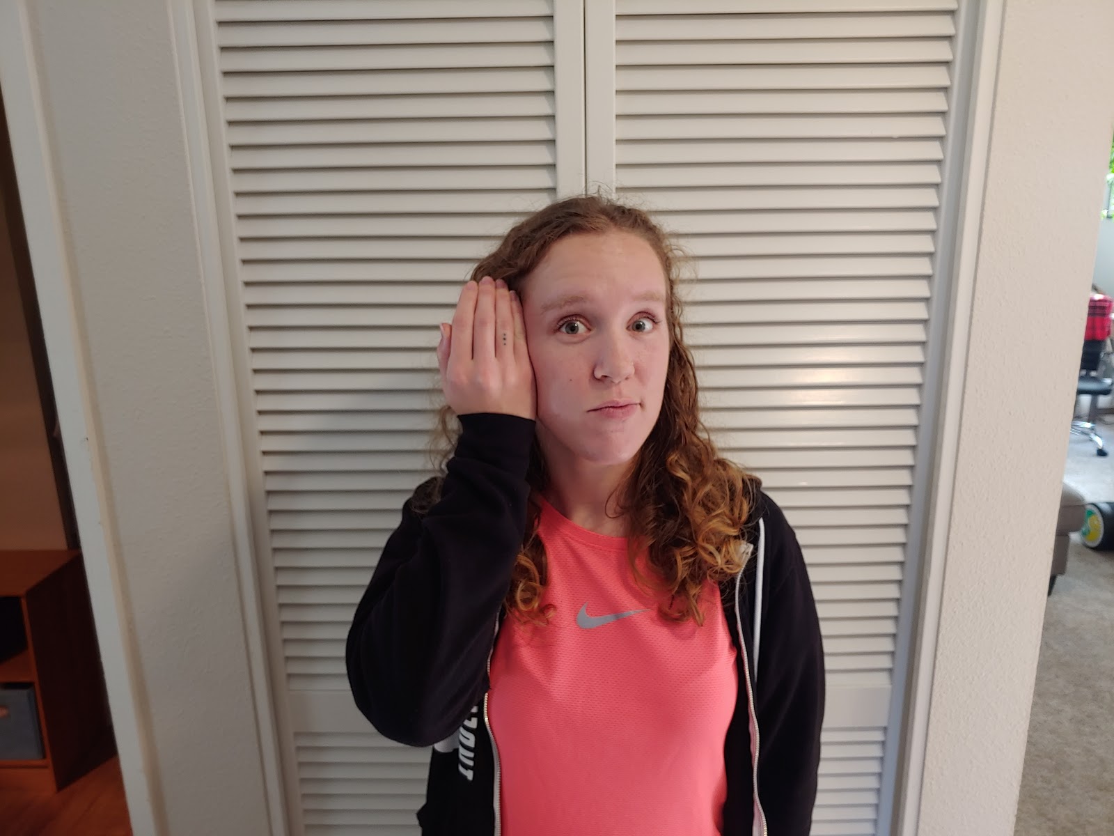 a picture of a person listening with backwards cupped ears, palm facing backward