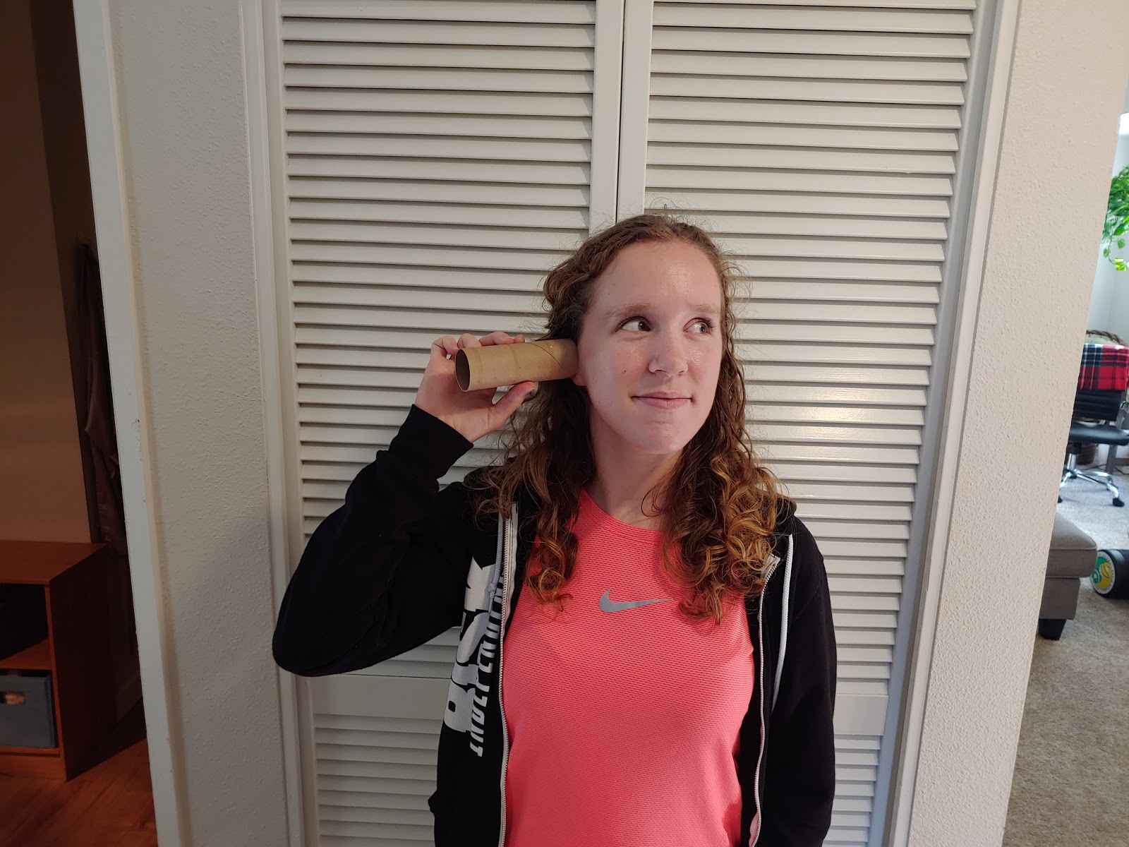 a picture of a person listening with a toilet paper roll pressed against their ear