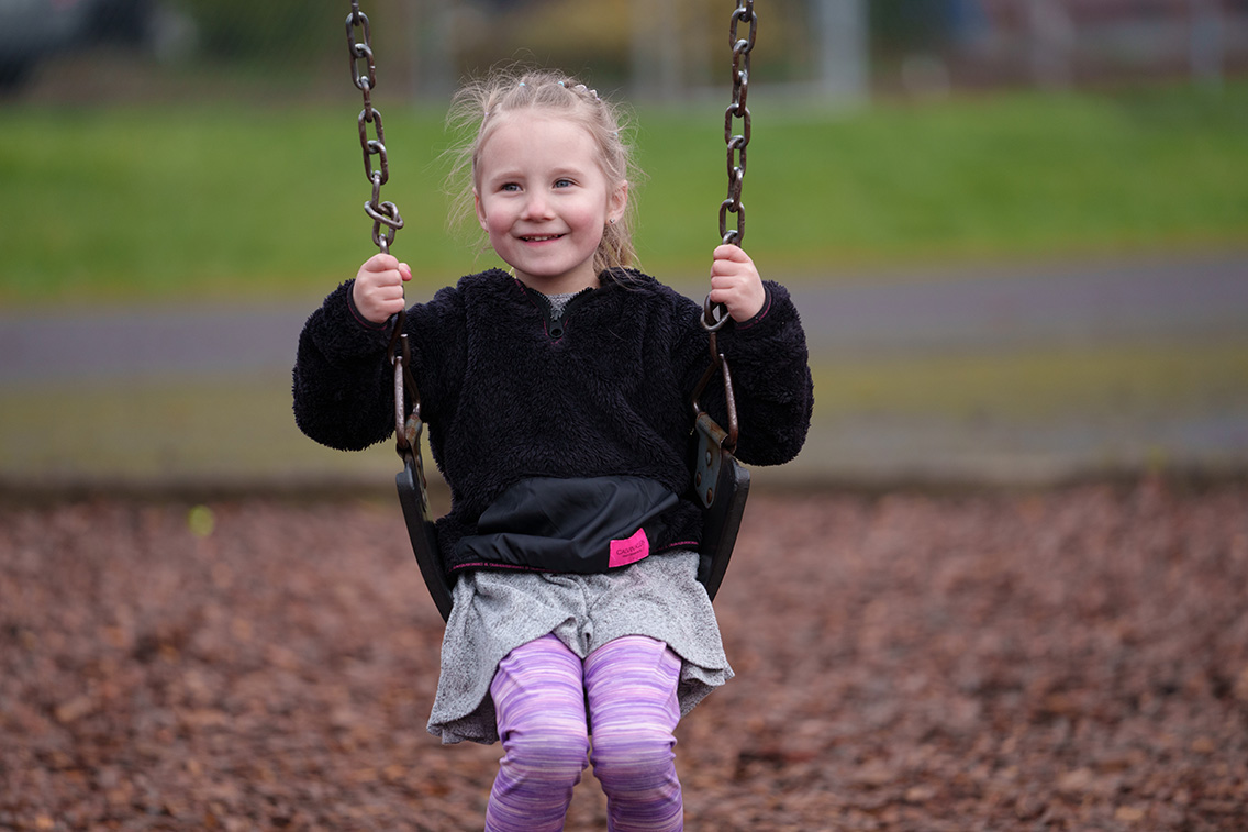 preschooler swings on a swing on the playground at mcbride elementary