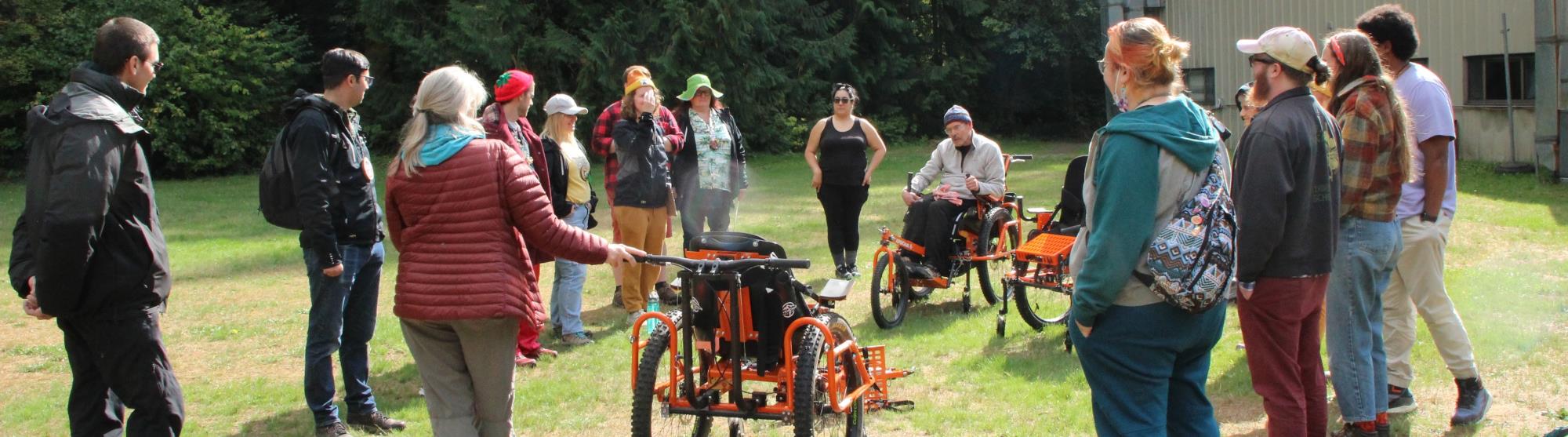 People standing around an Advenchair listening to instructions