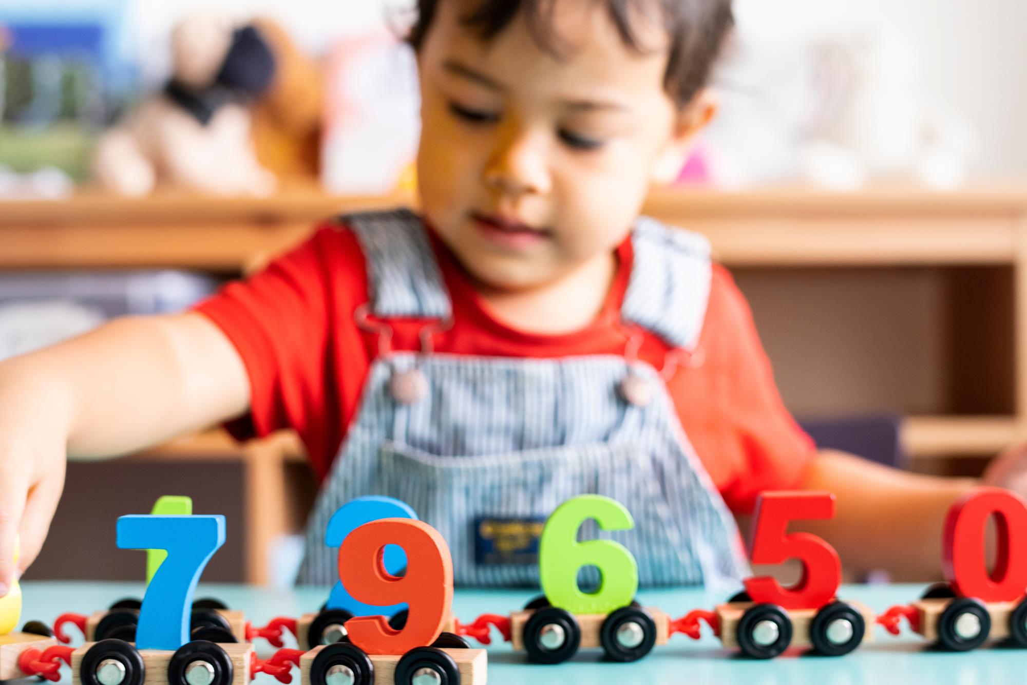 a child plays with a train set with numbers