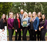 fiscal team members pose outside with financial reporting award