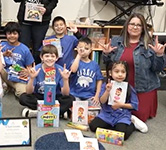 elementary students in blue shirts sign i love you