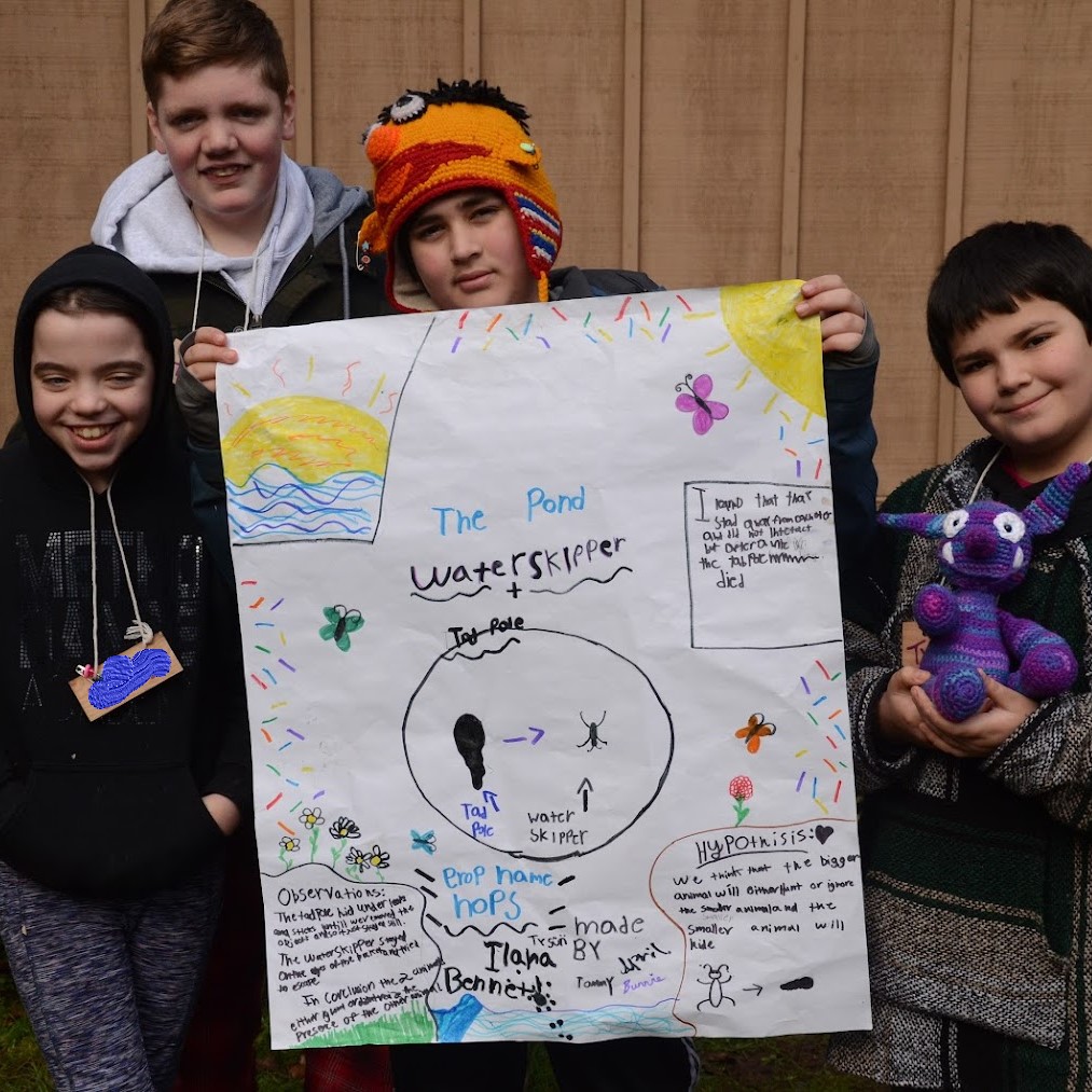 students displaying field study project: the pond