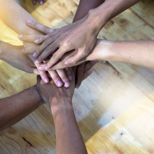 People put their hands together in a circle