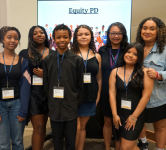 CAFE Summit students stand together and smile, posing in front of a screen that says Equity PD