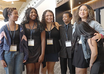 students pose for the camera in a large conference center