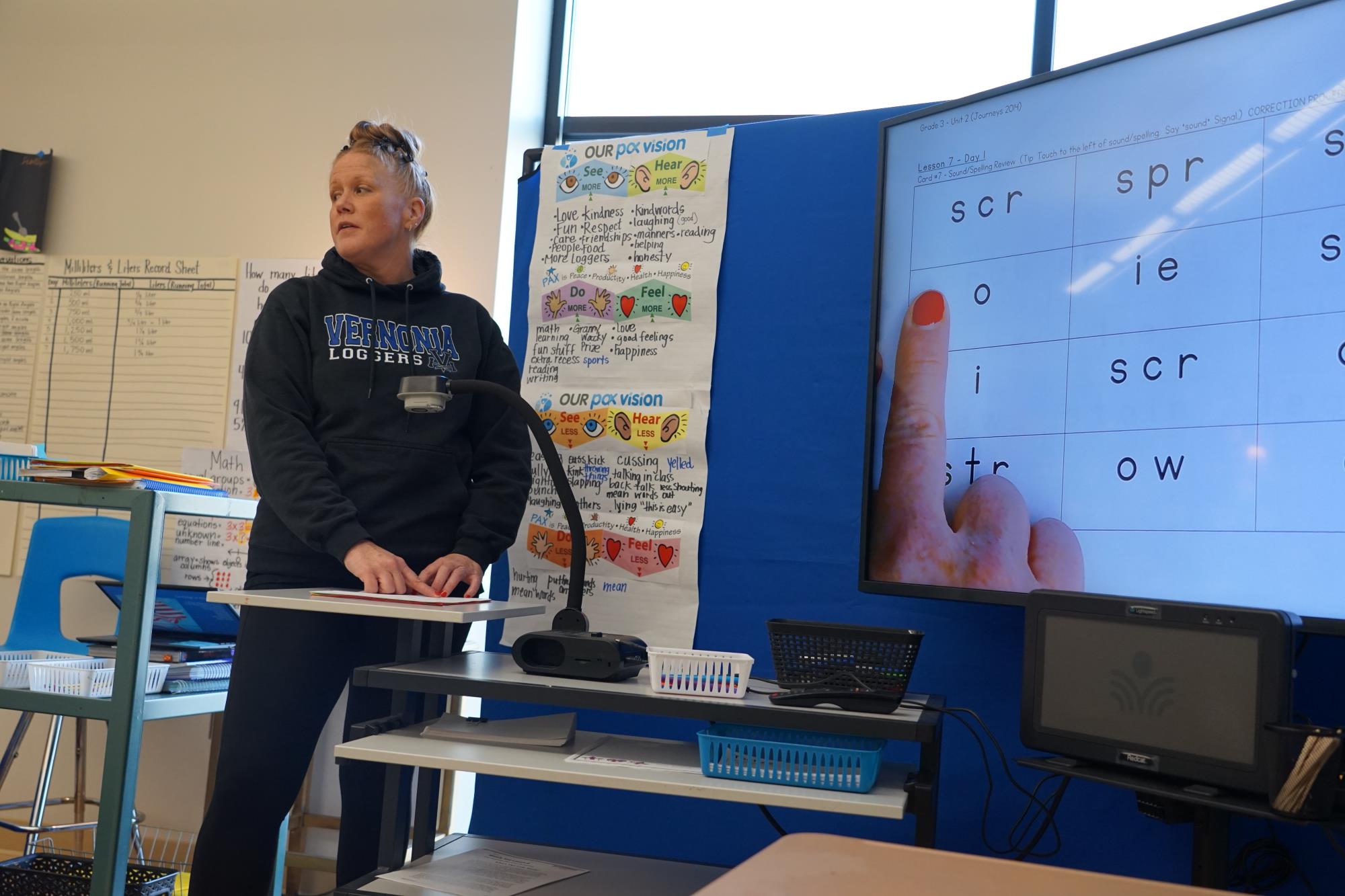 Allison McLeod points to an o and looks out at her class