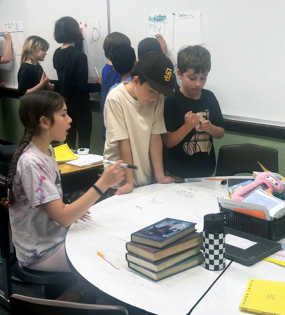 fourth and fifth graders work at a table in their classroom