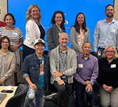 group of people pose for a photo in a conference room