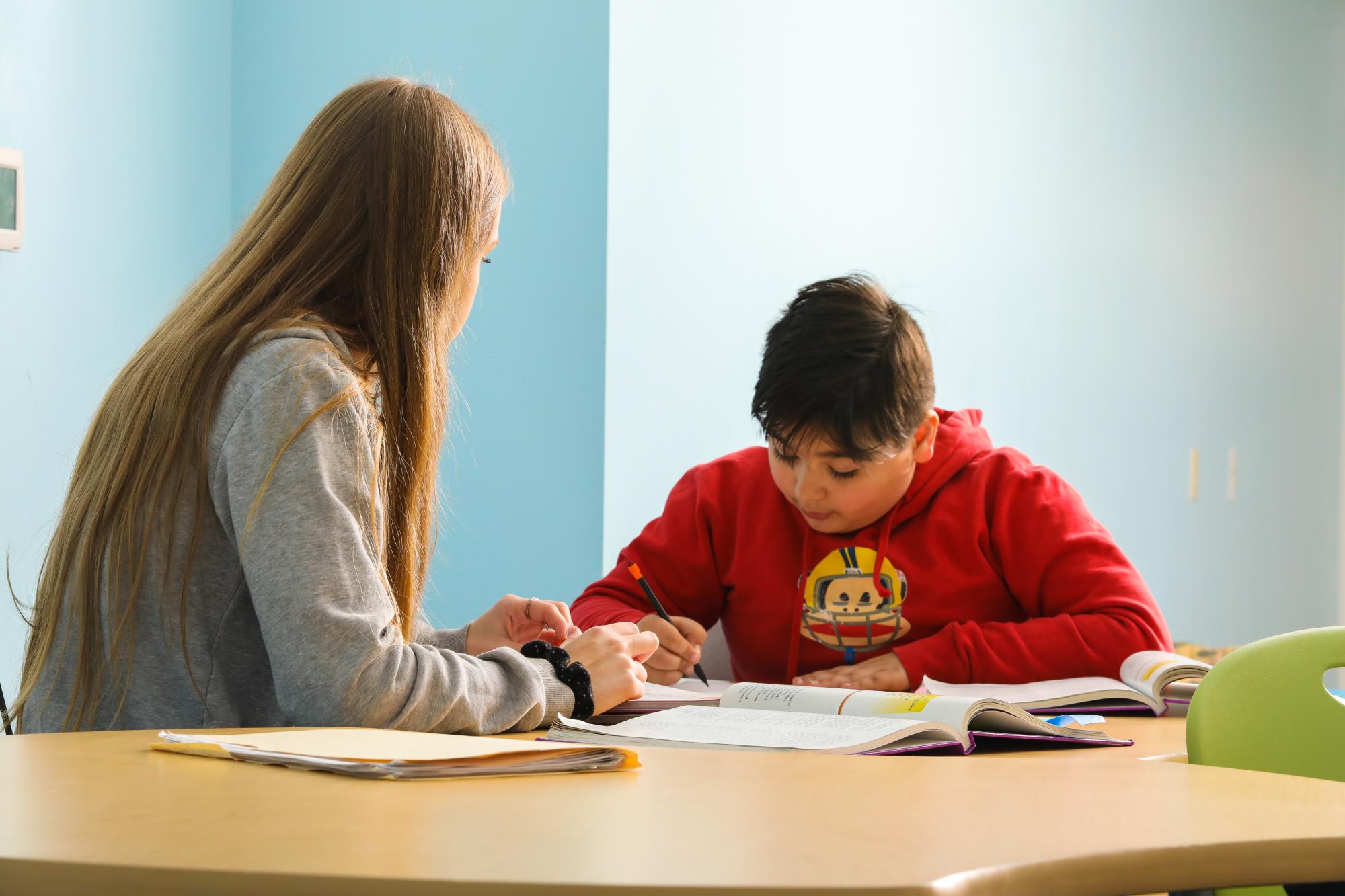 A Columbia Academy student works on a school assignment with support from an instructional assistant.