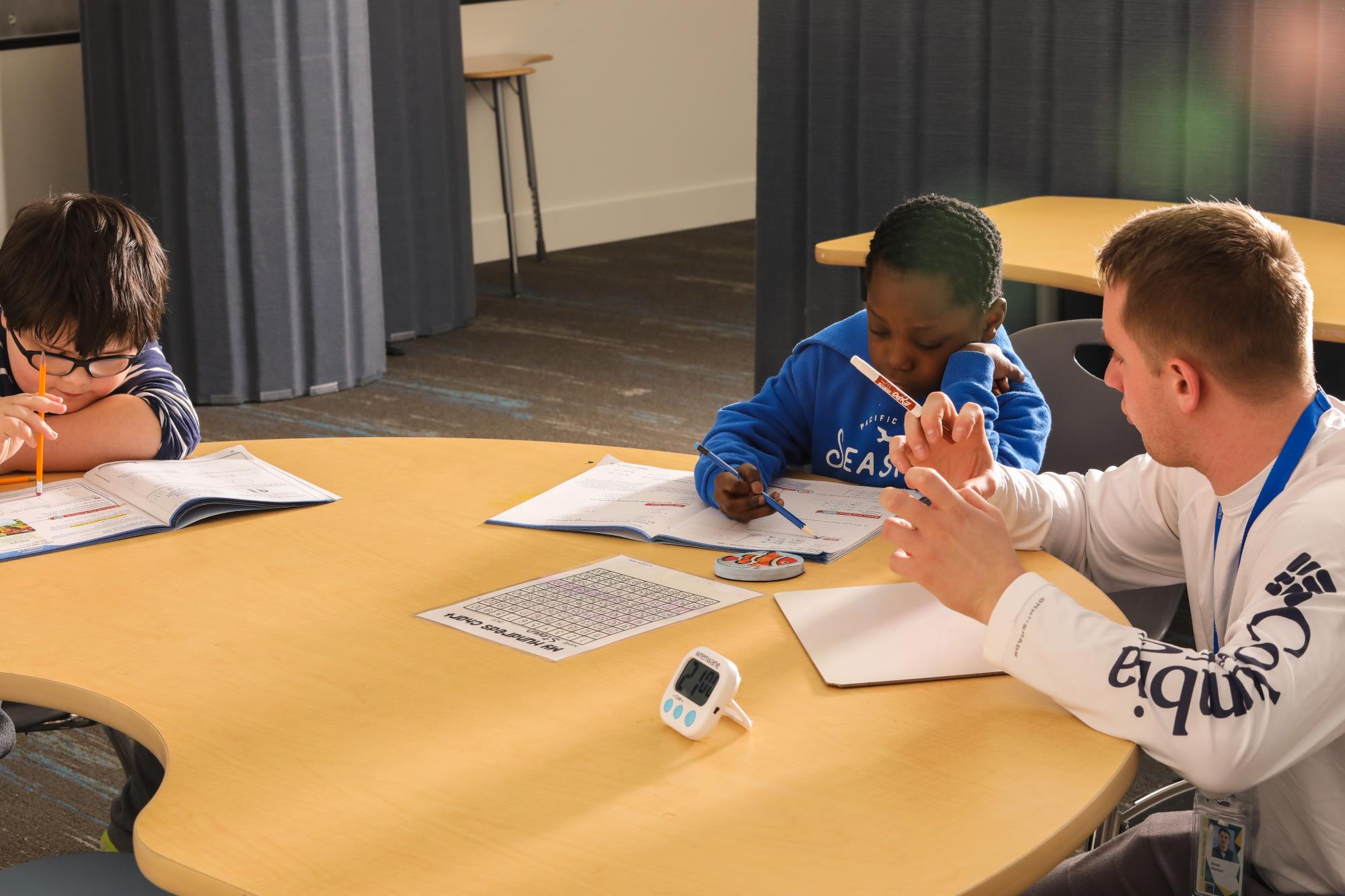 Two students at Columbia Academy receive instructional support at a table.